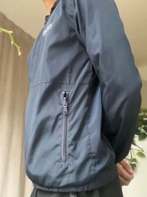 Blå Boss vind jacka  - Passar dig på 145-152 skulle jag säga. Storlek är 12xs. 