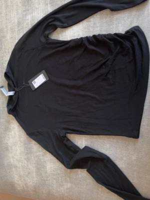 Svart långärmad - Snygg svart långärmad polotopp från Filippa K. Tillverkad i mjukt och stretchigt material som sitter skönt mot kroppen. Enkel och stilren design som passar till allt. Perfekt basplagg för garderoben.