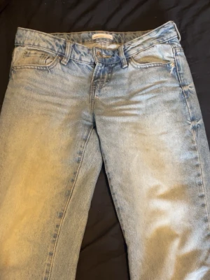 Ljusblå raka jeans - Säljer ett par ljusblå jeans med klassisk femficksdesign och raka ben. Jeansen har en snygg tvättad look och är tillverkade i bomull. Perfekta för en avslappnad stil och passar till det mesta i garderoben.