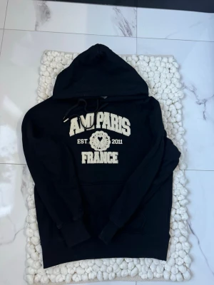 Svart hoodie från Ami Paris - Svart hoodie från Ami Paris med snyggt tryck, riktigt bra sick och inga konstigheter, tveka inte vid funderingar 