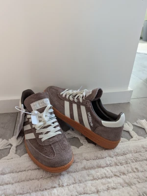 Adidas Spezial bruna sneakers mocka - Säljer ett par Adidas Spezial sneakers i brun mocka med vita detaljer. Väldigt trendiga just nu. Storlek 42. Pris 899kr