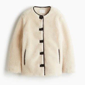 HELT NY OANVÄND Populär / slutsåld Gräddvit / ljusbeige teddyjacka H&M, XS - HELT NY oanvänd populär/slutsåld/trendig gräddvit/ljusbeige snygg och bekväm teddyjacka med stora mörka knappar framtill och rund hals. Jackan har lång ärm och två sidofickor. Perfekt för dig som vill ha en mysig och trendig look i vår. Storlek XS. Passar eventuellt även någon med Small. (Modellen på bilden bär Medium.) FELFRI. NYPRIS I BUTIK: 549 kr.