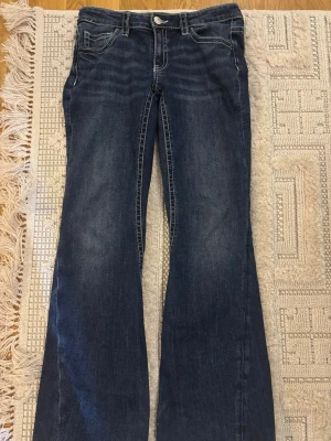 Mörkblå flare jeans med brodyr - Jättefina jeans från Gina. Använd ett par gånger men är i ett bra skick förutom att jag vikt det där nere och sytt för att dem var långa. Men passar de som är ungefär 163 cm. Storlek 170 