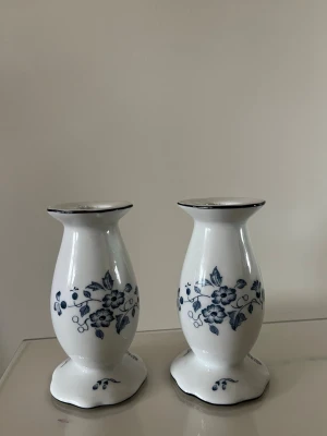 Christinholm porslinsljusstakar blåvit - Två eleganta porslinsljusstakar från Christinholm i vit färg med blått blommönster. Klassisk form med rundad fot och diskret blå kant upptill. Perfekta som dekoration eller till middagsbordet.