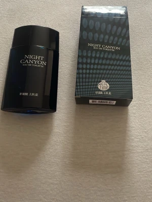 Night Canyon Eau de Toilette 100ml - Night Canyon Eau de Toilette från Real Time i en stilren, svart flaska med matchande svart kartong. Flaskan rymmer 100 ml och har en modern, kantig design. Perfekt för dig som gillar eleganta och mystiska dofter.