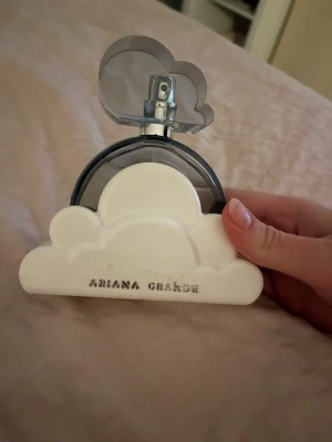 Ariana Grande Cloud parfym - Har kvar original förpackning du får med den Unik parfymflaska från Ariana Grande i form av NB moln. mörkgrå glasflaska med vit plastdetalj ﬂormad som ett moln och genomskinligt lock. Perfekt för dig som gillar snygg design och vill ha en ikonisk doft på hyllan. Helt full användning max 1 gång 90ml.
