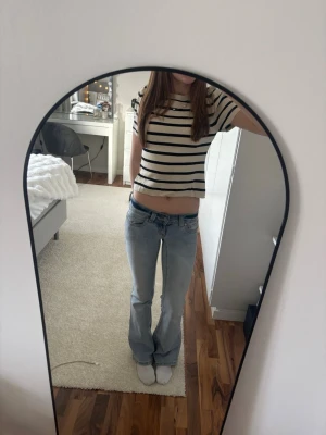 Randig stickad topp  - Säljer en beige och svart randig stickad topp från Gina tricot i storlek L men är väldigt liten i modellen. Använd endast ett par gånger därför i väldigt bra skick.