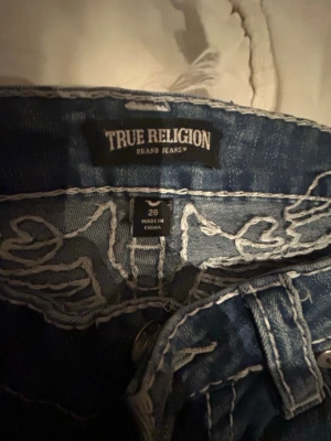 Blå bootcut jeans från True Religion - Snygga blå bootcut jeans från True Religion med tydliga vita kontrastsömar.❤️ Klassisk femficksmodell och låg midja.❣️(Dom kostar 1800kr och de är just därför jag har satt priset jag satt❤️)