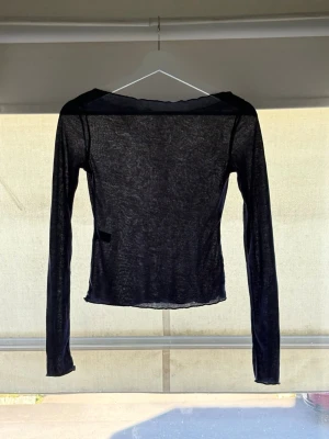 Mörkblå mesh långärmad topp - Snygg mörkblå långärmad topp i meshmaterial med lätt transparent känsla. Toppen har en smal passform och råa kanter vid halsringning och nederkant. TAR EMOT PRISFÖRSLAG 