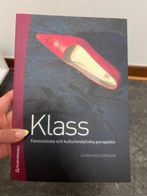 Klass: Feministiska perspektiv bok - Boken 'Klass: Feministiska och kulturanalytiska perspektiv' av Ulrika Holgersson. Omslaget är svart och mörkblått med en röd sko och hjärtmotiv. Perfekt för dig som pluggar genusvetenskap eller kulturstudier.