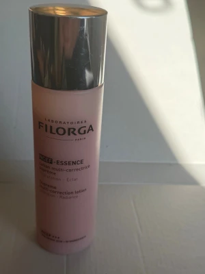 Filorga NCEF-Essence toner - Filorga NCEF-Essence är en lyxig toner i en ljusrosa flaska med silverfärgat lock. Produkten är en multi-correcting lotion som ger huden återfuktning och lyster. Perfekt för dig som vill boosta din hudvårdsrutin med extra glow.