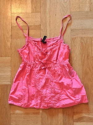 Korall Rosa topp - Söt korall rosa topp från H&M med spetsdetaljer vid halsringningen💓💓 Perfekt inför sommaren Toppen har en avslappnad passform och resår i midjan för en feminin siluett. Som ny💞
