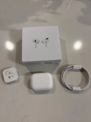 Apple AirPods Pro med laddningsetui - Säljer ett par vita Apple AirPods Pro 3 med trådlöst laddningsetui. Hörlurarna har en stilren och kompakt design med silikonproppar och svart detalj på varje snäcka. Paketet inkluderar originalkartong, laddningskabel och allt som är i orginalkartongen, dom har använts i nån månad så dom är jätte fina och fräscha, ljudet är jätte bra och passar perfekt i öronen