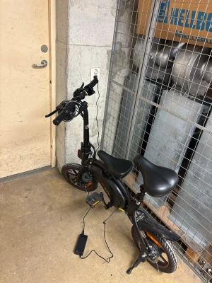 Svart DYU elcykel med laddare - DYU elcykel, funkar som den ska, har 2 sätten och har laddare till den. Ända problemet med den är att bromsen är ganska trasig men funkar lite ändå