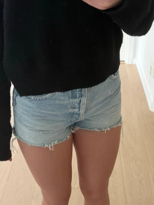 Ljusblåa jeansshorts - Säljer ett par ljusblåa jeansshorts med en klassisk femficksmodell i mjuk bomull, perfekta för varma dagar. Snygg och avslappnad passform som passar till det mesta.