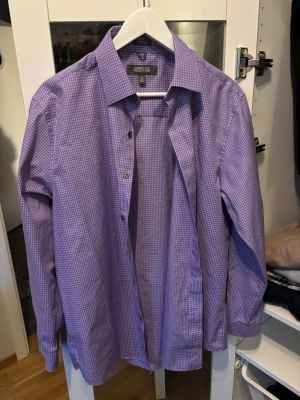Lila rutig skjorta Kenneth Cole - Snygg lila skjorta från Kenneth Cole Reaction i slim fit-modell. Skjortan har ett rutigt mönster, klassisk krage och långa ärmar. Perfekt för dig som gillar stilrena och moderna skjortor med lite färg. Skriv för frågor eller bud ! 