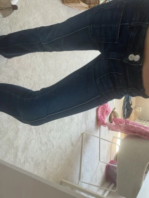 Mörkblå bootcut jeans med fickor - Säljer mörkblå bootcut jeans med  stora framfickor. 