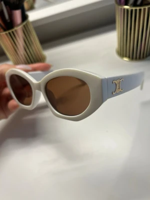  solglasögon med guldlogo - Säljer ett par vita solglasögon inspirerade av Celine, aldrig använda då färgen inte passar mig. Utan prislapp 