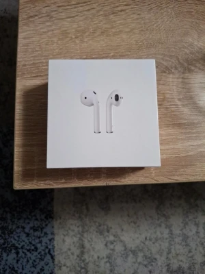 Apple AirPods med laddningsetui - Säljer ett par vita Apple AirPods med laddningsetui. Trådlösa in-ear hörlurar med stilren design och smidig passform. Perfekta för musik, samtal och träning. Kompatibla med iOS-enheter och har enkel anslutning via Bluetooth. 