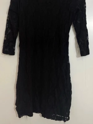 Svart spetsklänning med trekvartsärm - Snygg svart kortklänning i spets med blommönster och trekvartsärm. Klänningen har rund halsringning och är figurnära i modellen. Perfekt för dig som vill ha en elegant och stilren look.