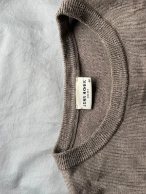 Beige stickad tröja John Henric - Snygg beige stickad tröja från John Henric i storlek M. Tröjan har rund halsringning och långa ärmar. Perfekt basplagg i mjukt material som passar till många olika stilar.