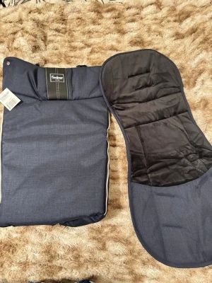 Mörkblå åkpåse och dyna till barnvagn - Säljer en mörkblå åkpåse  från Emmaljunga  helt ny