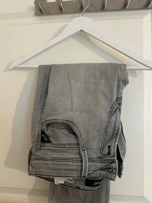 Replay Jens  - Säljer ett par gråa jeans från replay med rak passform och klassisk femficksdesign. Jeansen har bälteshällor och svarta detaljer på etiketten. Perfekta för en avslappnad och trendig look.