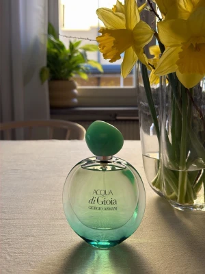 Acqua di Gioia parfym Giorgio Armani - Fräsch parfym från Giorgio Armani, Acqua di Gioia. Flaskan är rundad i glas med en grön toning och ett matchande grönt lock. Elegant och stilren design som känns lyxig och modern. Perfekt för dig som gillar fräscha och naturliga dofter.