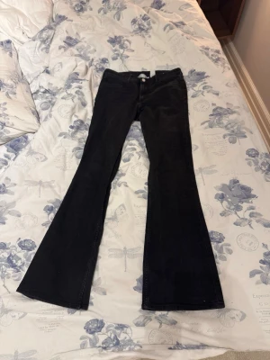 Svarta bootcut jeans - Säljer ett par svarta bootcut jeans med utsvängda ben. Jeansen har en snygg svart färg som inte tyder på urtvättad. och passar perfekt till en trendig vardagslook. Materialet är denim med mycket stretch för extra komfort.