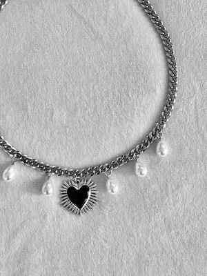 Kedjehalsband med pärlor och hjärta - Snyggt halsband i silverfärgad rostfritt stål med droppformade vita pärlor och ett svart hjärthänge med solstråle-design. Kedjan är chunky och ger en cool kontrast till de eleganta pärlorna. Perfekt accessoar för att lyfta din outfit.