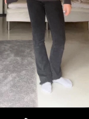 Mango svarta bootcut jeans.  - Säljer ett par svarta bootcut jeans från Mango med rå, fransad kant nertill!. Snygg passform som sitter tajt upptill och släpper ut vid benslutet.innerbens längd: 70cm midjemått: 30 cm