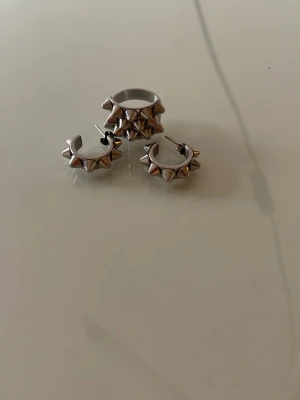 EDBLAD - Säljer ett par coola silvriga örhängen, en ring i creolmodell med små spetsiga nitar runt hela ringen. De är från Edblad och har använt ett par gånger. Om man bara vill köpa örhängerna eller bara ringen kontakta mig 💕