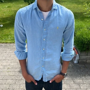 Ljusblå Ralph Lauren linneskjorta  - Ljusblå linneskjorta från Ralph Lauren perfekt nu till sommaren. Storlek S och passar 175-185 cm. Hör av dig vid frågor eller funderingar!