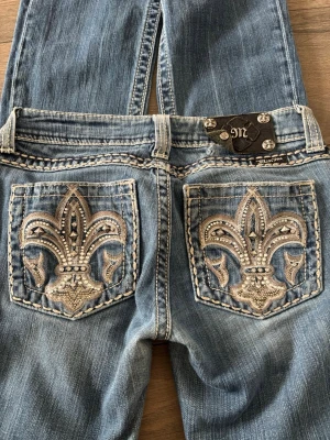 Miss Me jeans med broderade fickor - Säljer ett par super fina miss me jeans då jag inte använder dem längre.  Använts ett par gånger och har lite skav längst ner och en knappt som inte sitter fast på lappen (se på bilderna)  Mått:  Midja:74 Stuss: 80 Lår: 44 (Ca storlek 32) Pris går att diskutera 💕