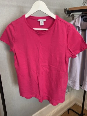 Rosa t-shirt från Amisu - En enkel och stilren rosa t-shirt från Amisu med rund halsringning och korta ärmar. Perfekt basplagg i garderoben och lätt att matcha med andra kläder. Tillverkad i mjuk bomull för en bekväm känsla.