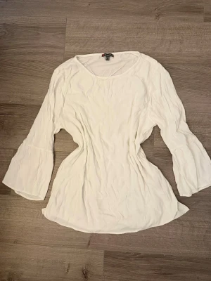 Vit blus från Street One - Snygg vit blus från Street One med rund halsringning och vida, långa ärmar. Blusen har en avslappnad passform och är tillverkad i ett lätt material som känns luftigt och bekvämt. Perfekt att styla med jeans eller kjol.