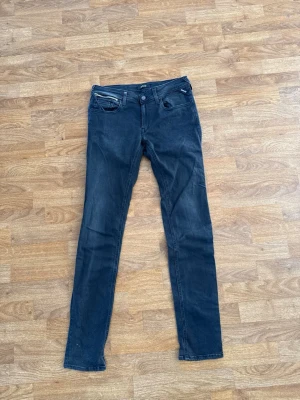 Svarta slimfit jeans från replay - Säljer ett par svarta slimfit jeans med klassisk femficksmodell och låg midja och en extra dragkejda. Jeansen har bra passform hela vägen ner och är perfekta för en trendig och avslappnad look. Obs! Jeansen har en extra dragkedja på högerficka! Jeansen är i storlek w30 l32. Materialet är stretchigt för extra komfort. Pris kan diskuteras ✅