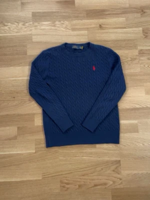 Marinblå stickan Polo Ralph Lauren tröja - Jag säljer en stilig marinblå stickad Polo Ralph Lauren tröja. Tröjan är stilig och passar med det mesta. Perfekt nu till våren och sommarkvällar. Tröjan är köpt för 1500kr och är knappt använd då den var för stor på mig. Är villig att sälja den för 650kr. Hör av dig om du vill diskutera pris eller mer bilder.