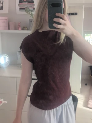 Mörkröd ribbad topp - En mörkröd ribbad topp med korta ärmar och rund hals. Toppen har en slim passform och är perfekt att styla med både jeans och kjol. Materialet känns mjukt och följsamt mot huden. Storlekslappen har jag klippt bort tidigare för den kliade men den är i storlek S från lager 157.