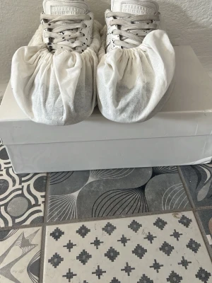 Maison Margiela svartvita sneakers - Unika sneakers från Maison Margiela i vitt läder med svart färgstänk-design. Klassisk låg modell med vita skosnören och tydlig logotyp på plösen. Snygg kontrast mellan det vita och svarta gör dem till ett statement-piece för dig som gillar streetwear.    Pris kan diskuteras om ni har frågor skriv!!!!!!