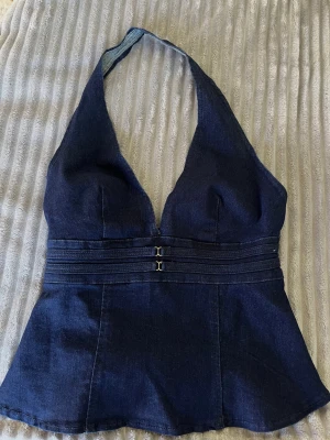 JEANSTOPP - Säljer denna festliga jeanstopp med halterneck och öppen rygg! Toppen har aldrig använts då jag råkade beställa två stycken likadana. Har fått så mycket komplimanger när jag haft på mig den!  Är något stor för mig som normalt brukar ha xs, skulle nog passa perfekt för s. 