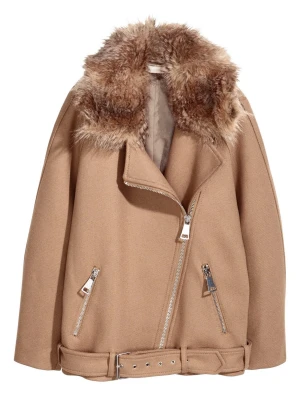 Beige jacka från H&M - Beige jacka med bred krage i brun fuskpäls, silvriga dragkedjor och bälte i midjan. Två fickor framtill och bikerinspirerad design. Materialet är tyg med detaljer i fuskpäls, vilket ger en trendig och mysig look.