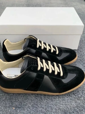 Svarta Maison Margiela gats - Masion  margiellas jag har använt de lite men inget förstört endas lite crease på de. Har köpt de på plick nya och använt ett få tall gånger.