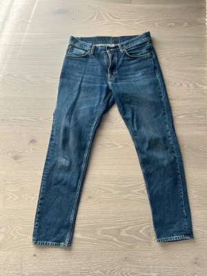 Nudie Jeans Steady Eddie 2 Blue Soil - Säljer ett par nice Nudie jeans i modellen Steady Eddie 2, med slitningen blue soil. En snyggare mörkare blå som passar bra till det mesta! Storleken är 33 i midja och 34 i Längd. Byxan är i väldigt bra skick då den inte används så mycket och är relativt nyköpt. Bara att höra av sig vid funderingar!:)