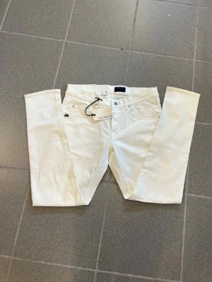 Vita skinny jeans från Tiger of Sweden  - Snygga vita jeans från Tiger of sweden med klassisk femficksdesign och bälteshällor. Jeansen har en slim passform och är tillverkade i ett mjukt denim-material som ger en skön känsla. Perfekta för dig som vill ha en clean och modern look.