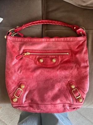 Balenciaga hobo bag - Såååå fin balenciaga väska! Rosa/röd i färgen med guldiga detaljer. Lite slitet på handtaget som jag lagat så gott det går hos skomakare. Syns inte alls när man bär den. 🥰❤️