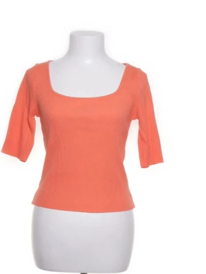 Ribbad koral topp med trekvartsärm - Trendig orange ribbad topp med fyrkantig ringning och trekvartsärm. Perfekt för dig som gillar en enkel men snygg stil. Toppen har en figurnära passform och är superenkel att matcha med jeans eller kjol.
