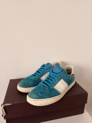Valentino flycrew  - Snygga sneakers i turkos mocka med vita detaljer och vita sulor. Skorna har blå skosnören och en vit panel på sidan samt vit hälkappa i skinn. Klassisk låg modell som passar till många olika stilar. Skorna är i okej skick men går att lösa. Skriv till mig vid minsta fundering! 