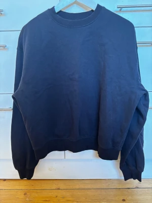Svart sweatshirt från Weekday storlek XS - En klassisk svart sweatshirt med rund halsringning och ribbade muddar vid ärmslut och nederkant från Weekday. Tillverkad i bomull. Storlek XS
