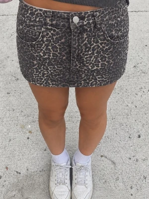 Leopardmönstrad kortkjol - Säljer en snygg kortkjol med leopardmönster. Kjolen har fem fickor, knapp och dragkedja framtill. str M, men tycker det kan sitta som S.                                                                                                                                                                    